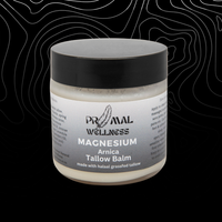Jar of Primal Wellness magnesium Arnica Tallow Balm on a black background