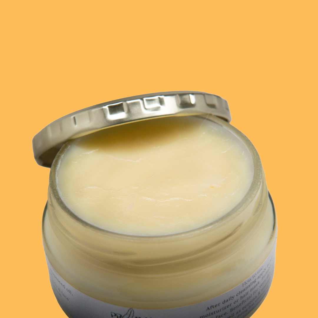 Jar of cream with a silver lid on an orange background