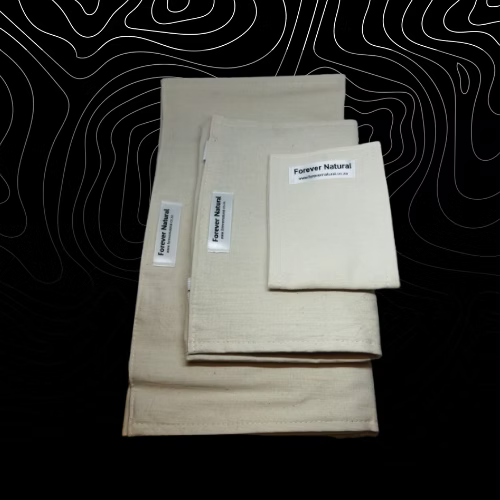 Stack of beige fabric sheets with 'Forever Natural' labels on a black background